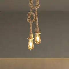 Dos lámparas de cuerda con bombillas Edison cuelgan del techo, creando un ambiente rústico y cálido.