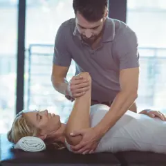 Fizjoterapeuta wykonuje ćwiczenia z pacjentką. Rehabilitacja i fizjoterapia pomagają w powrocie do zdrowia.