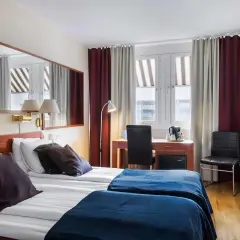 Dubbelrum med två sängar, mörkläggningsgardiner, skrivbord och spegel. Ett bekvämt och funktionellt rum på detta **sure hotel**.