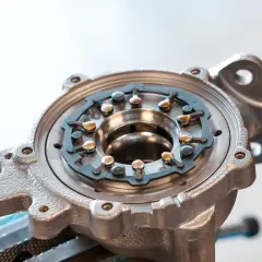 Metalowa obudowa turbo ze zmienną geometrią, z widocznymi łopatkami i mechanizmem regulacji.