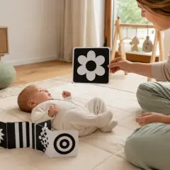 Niemowlę z zaciekawieniem ogląda czarno-białe karty kontrastowe, które pokazuje mu mama. Zabawki kontrastowe od kiedy są tak ważne dla rozwoju wzroku maluszka!