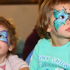 Bambine con colorate maschere di carnevale facili a forma di farfalla dipinte sul viso, pronte per la festa.