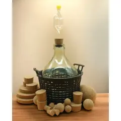 Wino w balonie z rurką fermentacyjną i korkami. Złe zamknięcie to powód, dlaczego wino kwaśnieje.