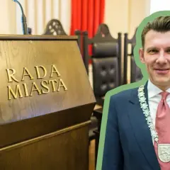 Burmistrz w garniturze i łańcuchu z herbem, na tle sali obrad Rady Miasta. Ciekawe, ile zarabia burmistrz?