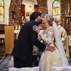 Para całuje się w kościele po ślubie kościelnym bez cywilnego. Panna młoda w pięknej sukni, pan młody w garniturze.