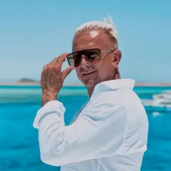 Mężczyzna w okularach przeciwsłonecznych, na tle błękitnego morza, przypomina mi tekst "Wake Me Up" Avicii.
