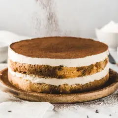 Ein köstlicher Tiramisu-Kuchen wird mit Kakaopulver bestäubt.