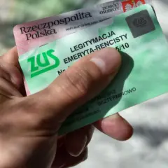 Dłoń trzyma zieloną legitymację emeryta-rencisty ZUS. Dokument potwierdza uprawnienia do świadczeń.