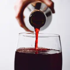 Rotwein wird in ein Glas gegossen. Die Frage, ob man Rotwein nach 2 Wochen noch trinken kann, beschäftigt viele Genießer.