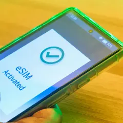 Smartfon z zieloną obudową pokazuje komunikat "eSIM Activated" i zielony znaczek. Tak działa esim.