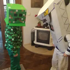 Dzieci w strojach z kartonu: jeden w zielonym kostiumie Creepera z Minecrafta, drugi w białym stroju robota. Świetny przykład, jak zrobić strój z kartonu!