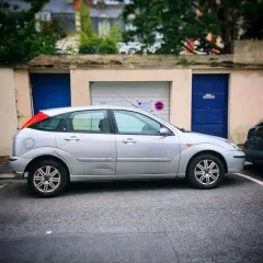 Une voiture argentée est garée devant un garage. Une autre voiture est garée juste derrière. Peut-on se garer devant son garage ?