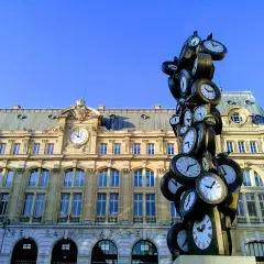 Sculpture de multiples horloges devant la gare Saint-Lazare, un monument parisien où le temps s'est arrêté.