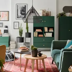 Zielony salon inspiracje: stylowe meble, kaktusy i sztuka na ścianach tworzą przytulną atmosferę.