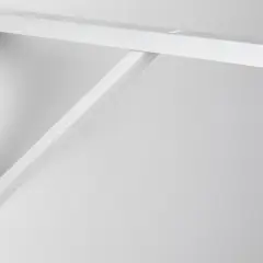Équerre blanche fixée au mur, prête à supporter un poids sur son côté le plus long.