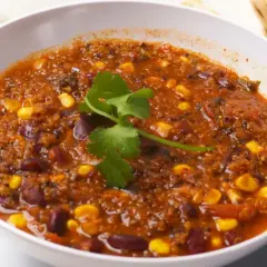 Gęste, aromatyczne chili sin carne z fasolą, kukurydzą i komosą ryżową, udekorowane świeżą kolendrą. Pyszne i sycące danie.