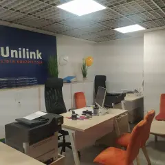 Nowoczesne biuro z logo Unilink, meblami i sprzętem biurowym.