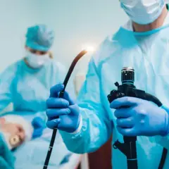Lekarz w rękawiczkach przygotowuje endoskop do gastroskopii i kolonoskopii za jednym razem NFZ.