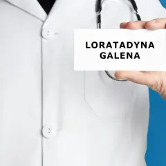 Lekarz trzyma kartkę z napisem "LORATADYNA GALENA". Stetoskop wisi na jego białej katanie.