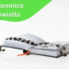 Otwarta księga z różańcem, symbolizującym tajemnicę światła.