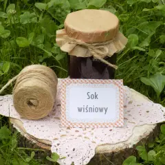 Sok z wiśni przepis: słoik domowego soku, sznurek i serwetka na pniu drewna. Idealny na lato!