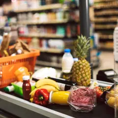 Zakupy spożywcze na taśmie: koszyk, owoce, warzywa, makaron, napoje. To typowe produkty FMCG, czyli szybko zbywalne towary.