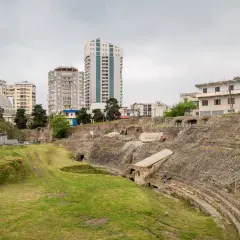 Ruiny amfiteatru w Durres, Albania, kontrastują z nowoczesnymi budynkami w tle.