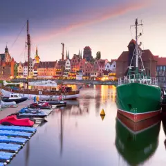 Port w Gdańsku o zachodzie słońca, idealne miejsce na jednodniowe wycieczki z Gdyni. Widoczne statki, kamienice i łodzie.