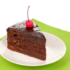 Pyszny kawałek tortu czekoladowego z wiśnią na wierzchu. Zastanawiasz się, ile kalorii ma taki kawałek tortu czekoladowego?
