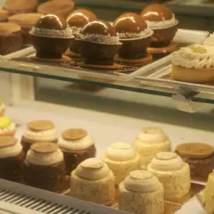 Słodkości w kawiarni cukierni Cafe Marona Gruszecki: czekoladowe kule, tartaletki z kremem i kolorowe babeczki.