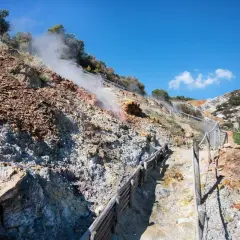 Sentiero nel **parco delle Biancane** con fumarole fumanti e rocce colorate.
