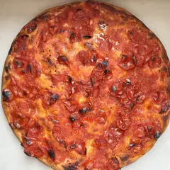 Focaccia rossa con pomodorini succosi e crosta dorata, un'esplosione di sapore mediterraneo.