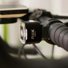 Czarne oświetlenie rowerowe ProX ARA II zamontowane na kierownicy. Idealne, jakie oświetlenie do roweru na nocne wyprawy.