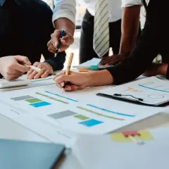 Zespół analizuje wykresy i dokumenty finansowe przy biurku.