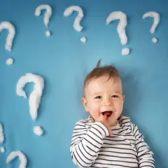 Un neonato sorridente con tante domande intorno. Quante volte fa la cacca un neonato di 1 mese?