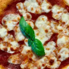 Eine köstliche italienische Sauerteig Pizza Margherita mit geschmolzenem Mozzarella und frischem Basilikum.