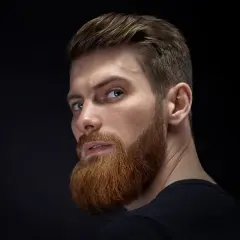 Hombre con barba y peinado moderno, ejemplo de cortes de pelo hombre elegante.