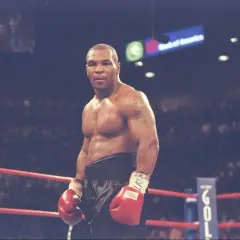 Mike Tyson in the ring, ready to fight. His intense gaze hints at the dedication required to train, making one wonder how long did Mike Tyson train a day to achieve such power.