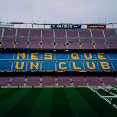 Trybuny Camp Nou z napisem "Més que un club" w żółtych literach, symbolizującym hymn Barcelony.