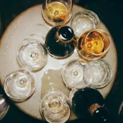 Naczynia z winem tworzą bukiet smaków i aromatów. Kilka kieliszków z bursztynowym trunkiem i ciemne butelki czekają na degustację.