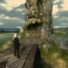 Geralt na platformie przed kamienną rzeźbą, w tle jezioro i miasto. Wygląda jak z ulepszeń do Wiedźmin 1.