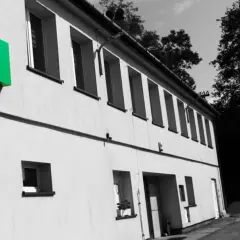 Hurtownia elektryczna ELTO zaprasza do przyłączenia się. Zielone logo ELTO na budynku i wtyczka symbolizują energię.