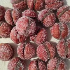 Dolci pesche di prato, ricoperte di zucchero scintillante, pronte per essere gustate.