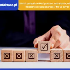 Dłoń układa kostki z symbolami. Jedna z nich, z zaznaczonym ptaszkiem, symbolizuje sukces w jdg.