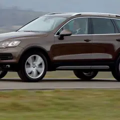 Brązowy Volkswagen Touareg w ruchu. Ten model to jeden z najmniej awaryjnych SUV-ów 10 letnich, idealny na długie podróże.