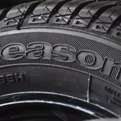 Zbliżenie na oponę z napisem "4Seasons", idealną do test opon całorocznych. Widać bieżnik i oznaczenia rozmiaru.
