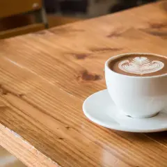 Biała filiżanka z kawą flat white, ozdobiona latte art. Dowiedz się, jak zrobić flat white w domu.
