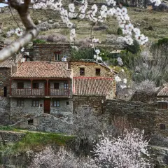 Casas de piedra con tejados rojos en un pueblo de montaña, ideal para saber como ir a la sierra de Madrid en primavera.