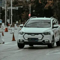 Voiture blanche lors d'un stage de sensibilisation à la sécurité routière, slalomant entre des cônes et des barrières.