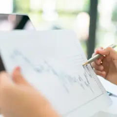 Analiza wykresu z danymi, gdzie widać aktualny euribor 1m. Dłoń z długopisem wskazuje na wykres.